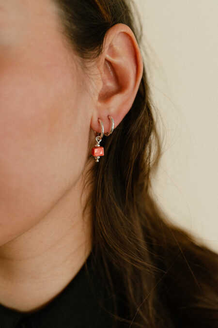 Boucles composées de perles en porcelaine fabriquées main à Limoges, montées sur créoles martelées. Couleur orange corail. Marque de bijoux artisanaux Les Aubepines.