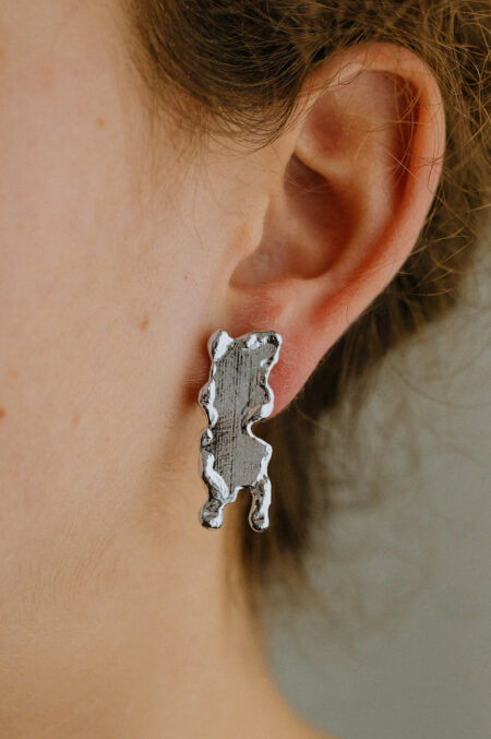 bijou sculptural argenté, boucles d'oreilles texturées et fondues. Bijou d'artiste, fabriqué par Agnès Nicot à Limoges, Les Aubépines