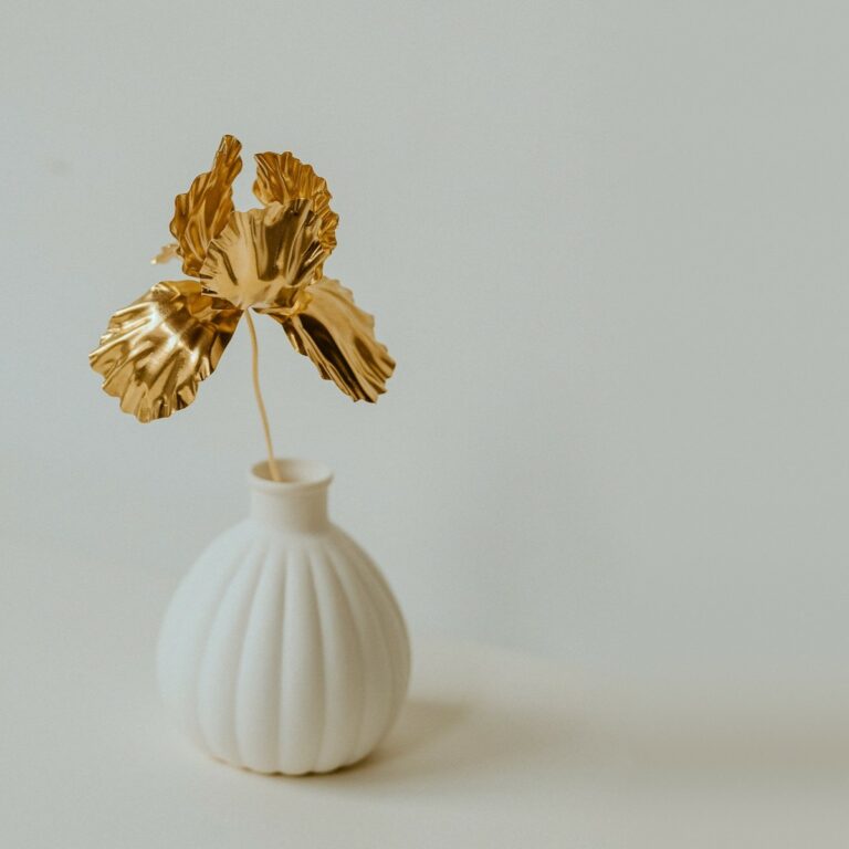 Iris en laiton doré dans un petit vase cannelé en porcelaine biscuit, sculpture végétale Les Aubépines